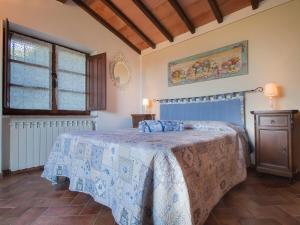 a bedroom with a bed with a blue bedspread at Holiday Home Poggiolo by Interhome in Roccastrada +19 photos