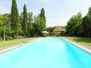 a large swimming pool in a yard with trees at Apartment Montecorneo-5 by Interhome in Montebello