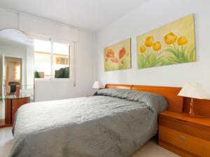 デニアにあるApartment Cascadas de la Marina-4 by Interhomeのベッドルーム1室(ベッド1台付)が備わります。壁には絵画2点が飾られています。
