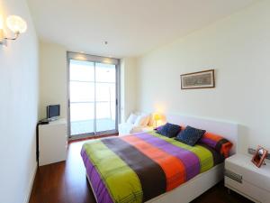 a colorful bed in a room with a window at Apartment Diagonal Mar by Interhome in Barcelona