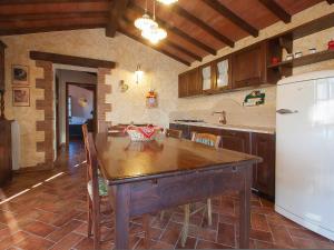a kitchen with a wooden table and a white refrigerator at Holiday Home Poggiolo by Interhome in Roccastrada