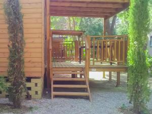 a wooden cabin with a staircase leading to a deck at Holiday Home Gineprino-3 by Interhome in Marina di Bibbona