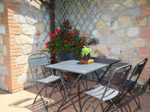 a table with three chairs and a potted plant on it at Holiday Home Poggiolo by Interhome in Roccastrada