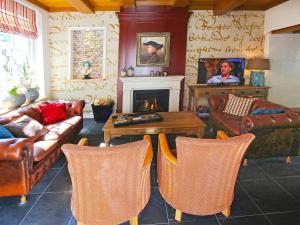 een woonkamer met lederen meubels en een open haard bij Villa Voc-Huys by Interhome in Enkhuizen