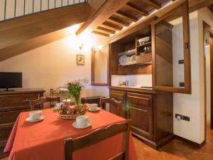 una cocina con una mesa con un bol de fruta. en Apartment Montecorneo-5 by Interhome en Montebello