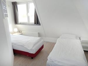 ノールトウェイクにあるHoliday Home de Witte Raaf-1 by Interhomeの窓付きの小さな部屋のベッド2台