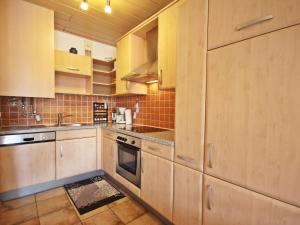 a kitchen with wooden cabinets and a stove top oven at Apartment Annemarie by Interhome in Glanz