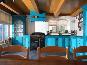 een blauwe keuken met een fornuis en blauwe kasten bij Villa VOC-Huys by Interhome in Enkhuizen