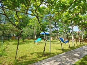 a park with two swings in the grass at Holiday Home Aron by Interhome in Umag