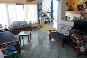 a living room with couches and a flat screen tv at Hotel Villa Del Mare in Bacoli