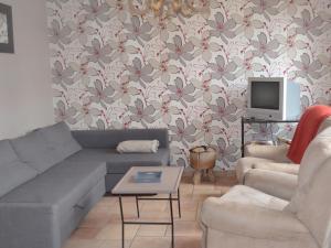 a living room with a couch and a tv at Holiday Home La Ferme de Gabrielle by Interhome in Le Bizet