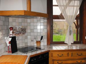 a kitchen with a stove top oven next to a window at Holiday Home La Ferme de Gabrielle by Interhome in Le Bizet