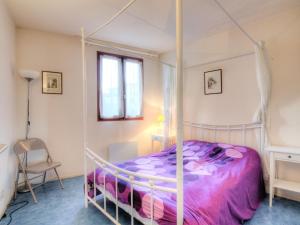 a bedroom with a canopy bed with a purple comforter at Apartment Le Grand Pavois by Interhome in Capbreton