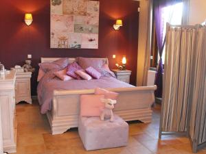 a bedroom with a bed with a dog sitting on a chair at Holiday Home La Ferme de Gabrielle by Interhome in Le Bizet