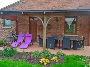 a patio with purple chairs and a table at Holiday Home La Ferme de Gabrielle by Interhome in Le Bizet