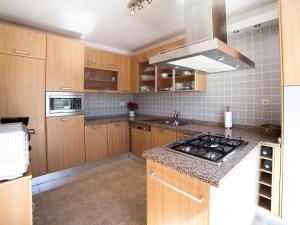 cocina con armarios de madera y horno con fogones en Villa Ingy by Interhome, en Calpe