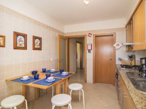 eine Küche mit 2 Tischen, Stühlen und einem Waschbecken in der Unterkunft Apartment Valérie by Interhome in Benfarras