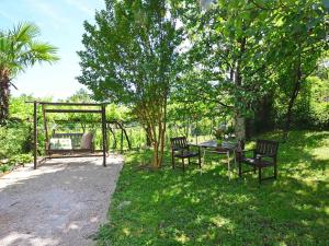 einen Garten mit einem Tisch, Stühlen und einer Schaukel in der Unterkunft Apartment Zvonko-1 by Interhome in Lovran