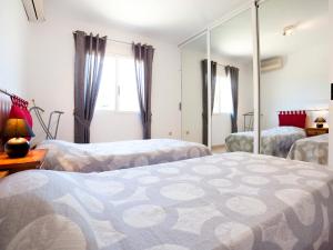 1 dormitorio con 2 camas y espejo en Villa Ingy by Interhome, en Calpe