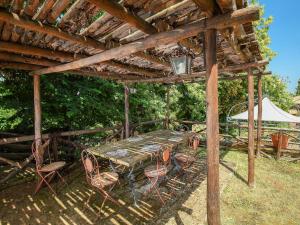 a wooden table and chairs under a wooden pergola at Villa Villa Mina by Interhome in Monte Compatri