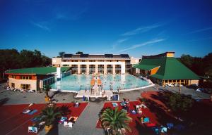 a large swimming pool in front of a building at Hangulat Vendégház / Apartman in Harkány