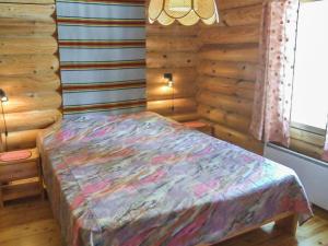 ein Schlafzimmer mit einem Bett in einer Blockhütte in der Unterkunft Holiday Home Kujalan lomat 2 by Interhome in Nissi