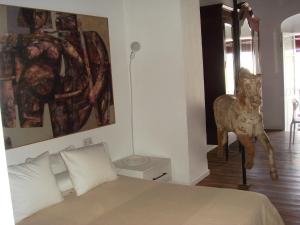 a bedroom with a bed and a statue of a horse at CENTRO DE ARTE HARINA DE OTRO COSTAL in Trigueros