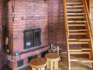 a brick fireplace with two stools in front of it at Holiday Home Kujalan lomat 2 by Interhome in Nissi