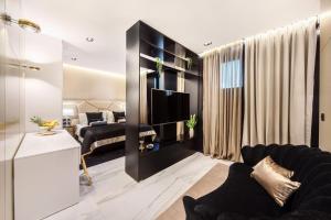 a living room with a black couch and a tv at Hotel Posh in Split
