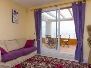 ein Wohnzimmer mit einer Couch und einer Glasschiebetür in der Unterkunft Apartment Vista Mar by Interhome in Cumbre del Sol