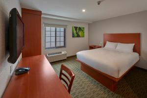 モンテレイにあるExtended Suites Monterrey Aeropuertoのベッドとデスクが備わるホテルルームです。