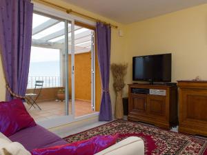 ein Wohnzimmer mit einem TV und einer Glasschiebetür in der Unterkunft Apartment Vista Mar by Interhome in Cumbre del Sol