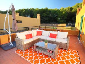 patio con divano, tavolo e ombrellone di Holiday Home Vistamar by Interhome a Ferrán