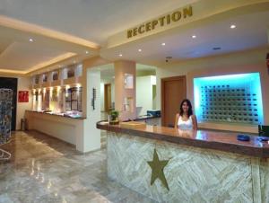 a woman standing at a bar in a store at Hotel Tigaki's Star in Tigaki