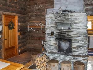 ルカにあるHoliday Home Rukakolo by Interhomeのログキャビン内のリビングルーム(石造りの暖炉付)