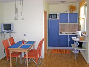 a kitchen with blue cabinets and a table and chairs at Holiday Home Goetheallee by Interhome in Krakow am See
