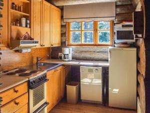 ルカにあるHoliday Home Rukakolo by Interhomeのキッチン(木製キャビネット、白い冷蔵庫付)