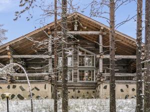 a log cabin in the woods with snow at Holiday Home Alte levi aatu by Interhome in Levi