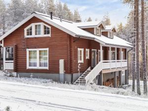 a wooden house with snow on the roof at Holiday Home Poronpurema a by Interhome in Levi