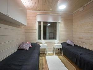 レヴィにあるHoliday Home Oppas lapland levi by Interhomeのベッド2台と窓が備わる小さな客室です。
