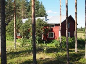 una casa roja en medio de un bosque de árboles en Holiday Home Raanumaja iii by Interhome, en Lampsijärvi