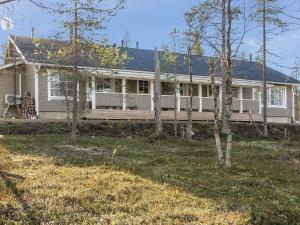 une grande maison blanche avec une véranda et des arbres dans l'établissement Holiday Home Aarre b by Interhome, à Saariselka