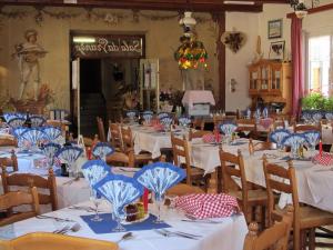 a dining room with tables with blue and white table settings at Albergo Rizzi in Pozza di Fassa