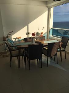a dining table and chairs on a balcony with the ocean at Beachfront, Juandolio in Juan Dolio