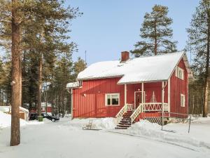 a red barn in the snow with trees at Holiday Home Levin mummola by Interhome in Köngäs