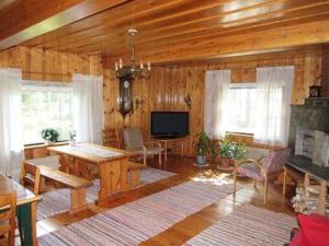 sala de estar con mesa y TV en Holiday Home Raanumaja iii by Interhome, en Lampsijärvi