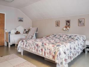 a bedroom with a bed with a floral bedspread at Holiday Home Levin mummola by Interhome in Köngäs