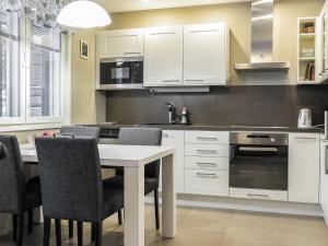 サーリセルカにあるHoliday Home Kotka a by Interhomeのキッチン(白いキャビネット、テーブル、椅子付)