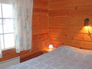 a bedroom with a bed in a wooden wall at Holiday Home Juolukka by Interhome in Pulju