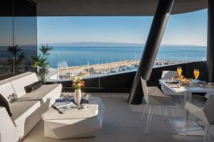 um restaurante com mobiliário branco e vista para o oceano em Posh Residence Luxury Suites em Split